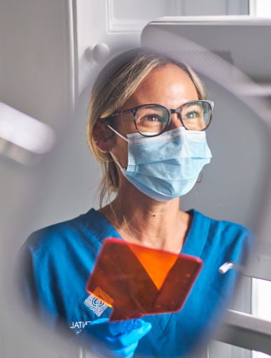 female clinician reflection in dental mirror